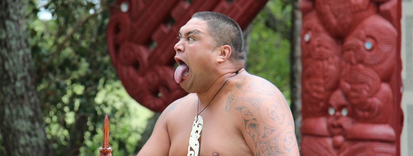 Homme Maori faisant une grimace lors de la danse Haka
